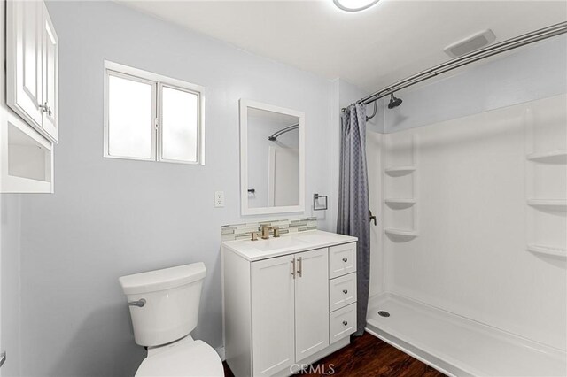 1040 W 3rd St, Pomona, CA 91766 - full bathroom featuring toilet, vanity, a shower with curtain, and wood finished floors