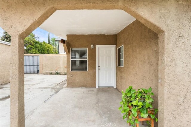 1040 W 3rd St, Pomona, CA 91766 - doorway to property with stucco siding and a patio