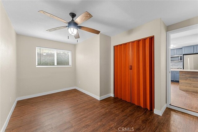 1040 W 3rd St, Pomona, CA 91766 - unfurnished bedroom featuring paneled fridge, dark wood finished floors, a closet, and baseboards