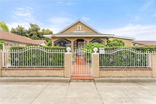 1040 W 3rd St, Pomona, CA 91766 - view of front facade featuring a fenced front yard, a gate, and stucco siding