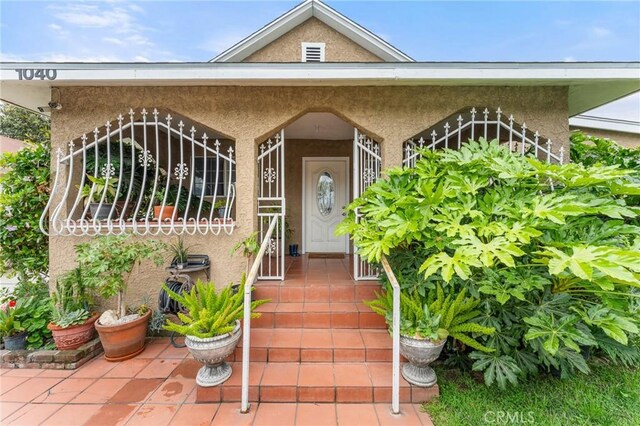 1040 W 3rd St, Pomona, CA 91766 - doorway to property featuring stucco siding