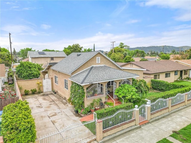 1040 W 3rd St, Pomona, CA 91766 - bungalow-style house with a gate, a porch, a fenced front yard, stucco siding, and driveway