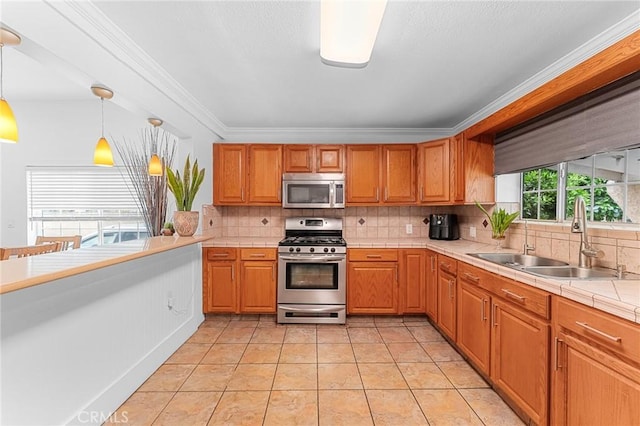 1040 W 3rd St, Pomona, CA 91766 - kitchen with stainless steel appliances, a sink, tile counters, decorative backsplash, and ornamental molding