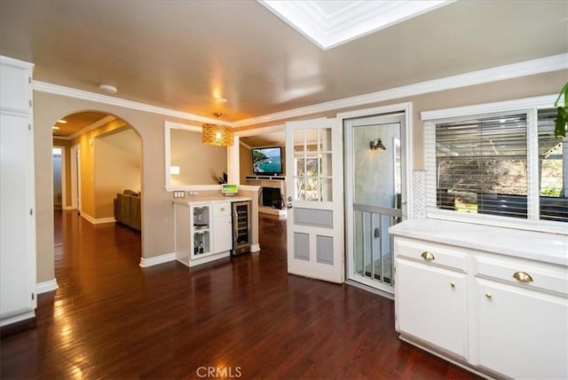 29911 Cactus Pl, Temecula, CA 92592 - kitchen with arched walkways, beverage cooler, light countertops, dark wood-style floors, and white cabinetry