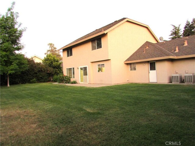1575 Santa Inez Ct, Merced, CA 95340 - back of house with cooling unit, a lawn, and stucco siding