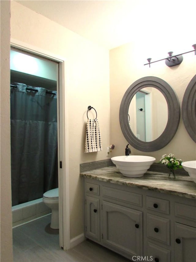 1575 Santa Inez Ct, Merced, CA 95340 - full bathroom with vanity, wood finished floors, toilet, curtained shower, and baseboards