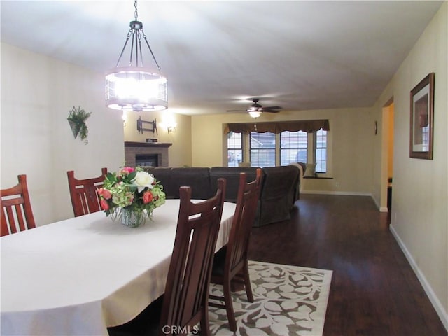 1575 Santa Inez Ct, Merced, CA 95340 - dining space featuring dark wood finished floors, a ceiling fan, baseboards, and a fireplace