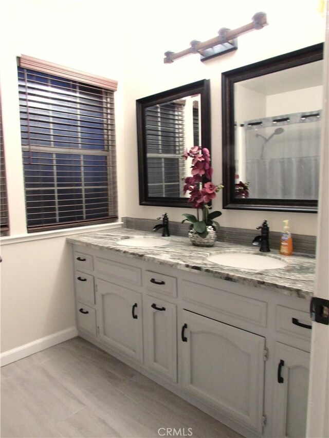 1575 Santa Inez Ct, Merced, CA 95340 - full bath with double vanity, baseboards, and wood finished floors