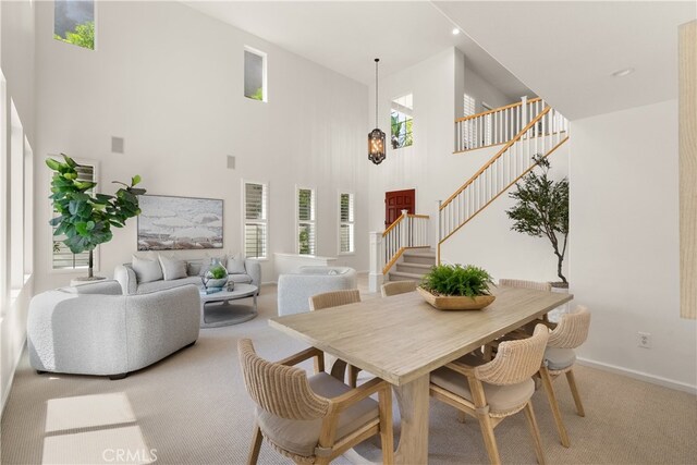 19139 Chandon Ln, Huntington Beach, CA 92648 - dining area with a towering ceiling, stairs, carpet flooring, and baseboards