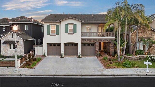 19139 Chandon Ln, Huntington Beach, CA 92648 - view of front facade featuring concrete driveway, an attached garage, stucco siding, a balcony, and stone siding