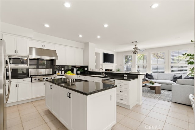 19139 Chandon Ln, Huntington Beach, CA 92648 - kitchen featuring under cabinet range hood, open floor plan, stainless steel appliances, a peninsula, and light tile patterned flooring