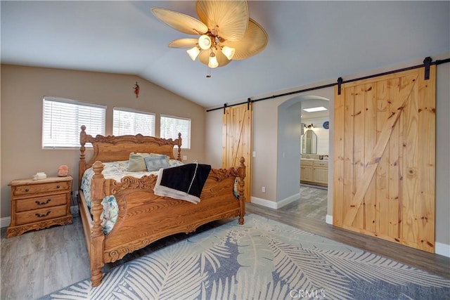 1121 Rose Ct, Grover Beach, CA 93433 - bedroom with a barn door, wood finished floors, lofted ceiling, multiple windows, and baseboards