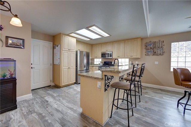 1121 Rose Ct, Grover Beach, CA 93433 - kitchen featuring appliances with stainless steel finishes, a kitchen bar, plenty of natural light, and baseboards