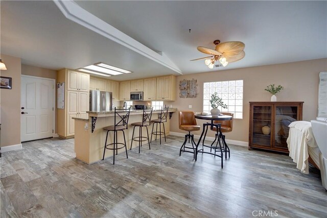 1121 Rose Ct, Grover Beach, CA 93433 - kitchen featuring appliances with stainless steel finishes, a peninsula, a breakfast bar, and light wood-style floors