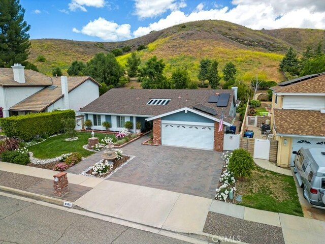 6505 Smoke Tree Ave, Oak Park, CA 91377 - view of front of home featuring a mountain view, a gate, driveway, and roof mounted solar panels