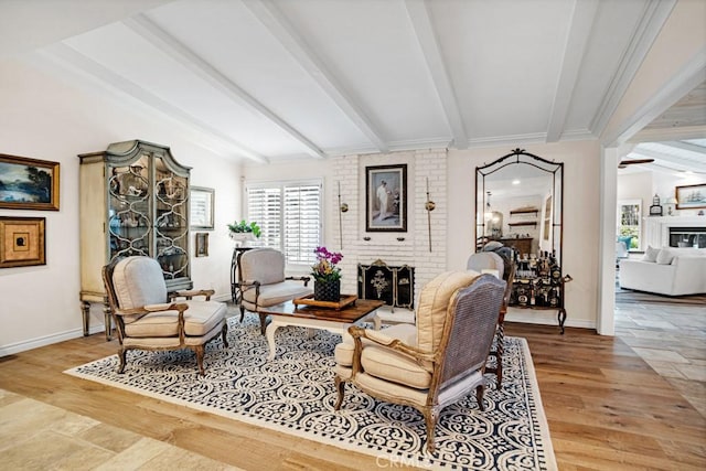 6505 Smoke Tree Ave, Oak Park, CA 91377 - living area featuring a brick fireplace, beamed ceiling, healthy amount of natural light, and baseboards