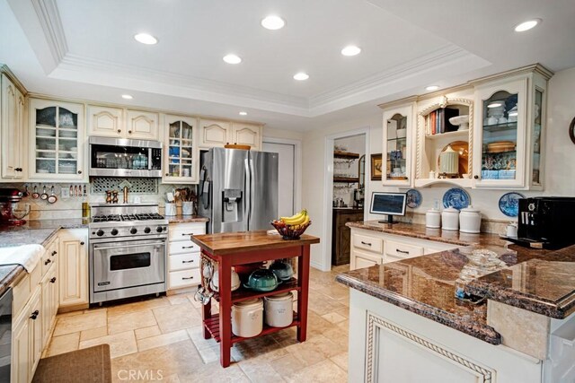 6505 Smoke Tree Ave, Oak Park, CA 91377 - kitchen with appliances with stainless steel finishes, cream cabinetry, a tray ceiling, open shelves, and crown molding