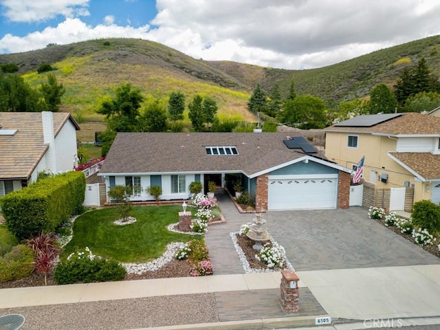 6505 Smoke Tree Ave, Oak Park, CA 91377 - view of front of home with a mountain view, driveway, an attached garage, and brick siding