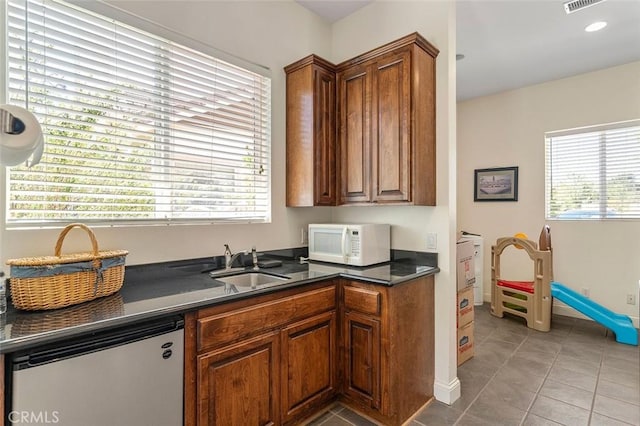 41275 Hacienda Dr, Murrieta, CA 92562 - kitchen with white microwave, a sink, dark countertops, and light tile patterned floors