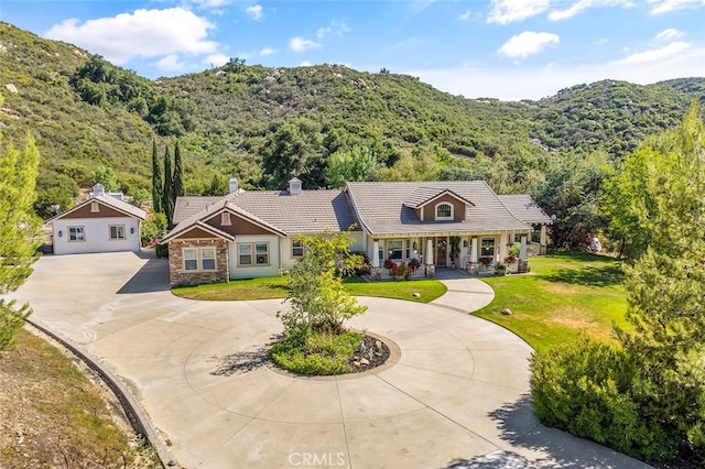 41275 Hacienda Dr, Murrieta, CA 92562 - view of front of property with curved driveway, a chimney, stone siding, a tile roof, and covered porch