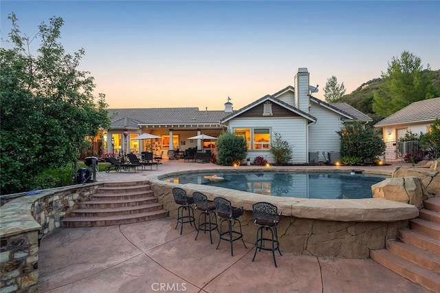 41275 Hacienda Dr, Murrieta, CA 92562 - pool at dusk with a patio area and an outdoor pool