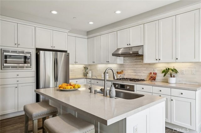 114 Desert Lotus, Irvine, CA 92618 - kitchen featuring appliances with stainless steel finishes, under cabinet range hood, a kitchen breakfast bar, white cabinets, and recessed lighting