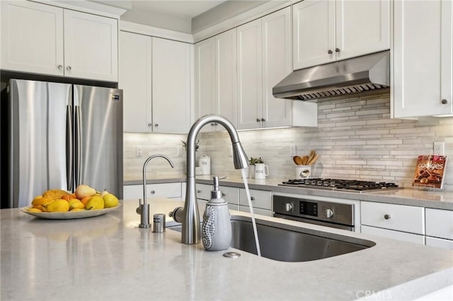 114 Desert Lotus, Irvine, CA 92618 - kitchen featuring appliances with stainless steel finishes, under cabinet range hood, white cabinetry, and backsplash