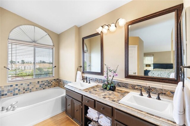 40678 Alondra Dr, Murrieta, CA 92562 - bathroom featuring ensuite bathroom, double vanity, a bath, and wood finished floors