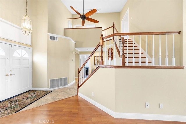 40678 Alondra Dr, Murrieta, CA 92562 - foyer featuring stairs, a ceiling fan, a towering ceiling, wood finished floors, and baseboards