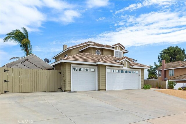 40678 Alondra Dr, Murrieta, CA 92562 - view of front of property with concrete driveway, a tile roof, an attached garage, and a chimney