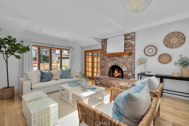 1330 8th St, Manhattan Beach, CA 90266 - living room featuring wood finished floors, a brick fireplace, lofted ceiling, and a baseboard radiator