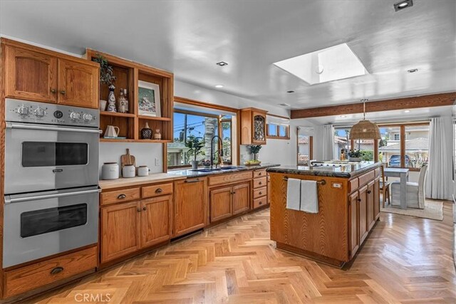 1330 8th St, Manhattan Beach, CA 90266 - kitchen with double oven, a skylight, a sink, brown cabinetry, and recessed lighting