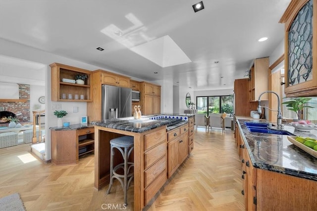 1330 8th St, Manhattan Beach, CA 90266 - kitchen with open shelves, appliances with stainless steel finishes, a sink, dark stone counters, and a center island