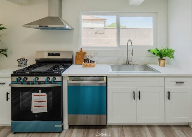 14609 Clark St, Baldwin Park, CA 91706 - kitchen featuring stainless steel gas range oven, wall chimney exhaust hood, dishwasher, a sink, and white cabinets