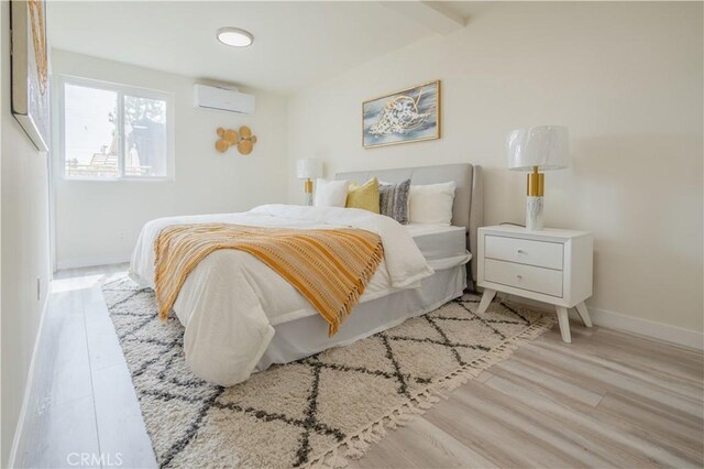 14609 Clark St, Baldwin Park, CA 91706 - bedroom featuring baseboards, an AC wall unit, and light wood-style flooring