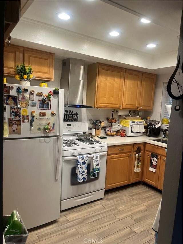 708 W Lambert Rd Unit 6, La Habra, CA 90631 - kitchen featuring white appliances, wall chimney exhaust hood, a sink, a raised ceiling, and light countertops
