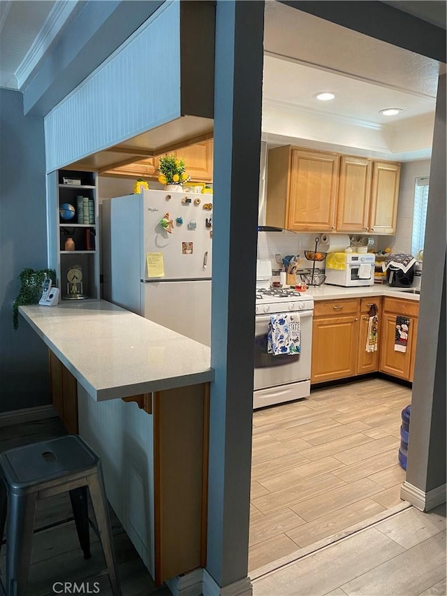 708 W Lambert Rd Unit 6, La Habra, CA 90631 - kitchen featuring white appliances, light wood finished floors, a kitchen bar, light brown cabinets, and crown molding