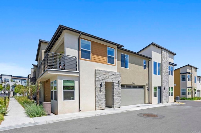 7902 Belluno Way, San Diego, CA 92126 - view of front of house with stone siding, stucco siding, a balcony, and a garage