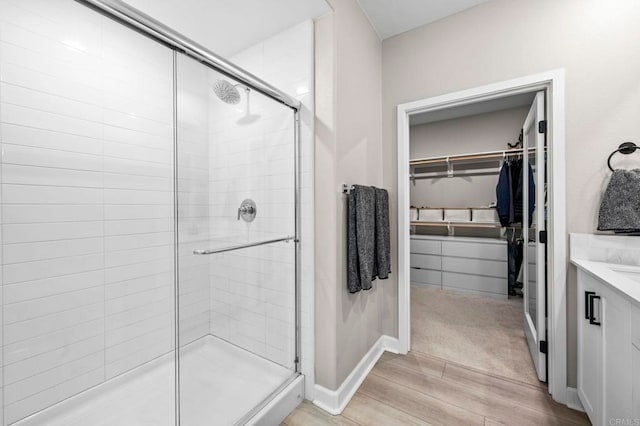 7902 Belluno Way, San Diego, CA 92126 - full bath with wood finished floors, a stall shower, a walk in closet, and vanity