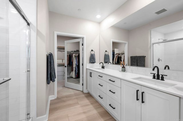 7902 Belluno Way, San Diego, CA 92126 - full bathroom featuring a spacious closet, double vanity, a shower stall, wood finished floors, and recessed lighting