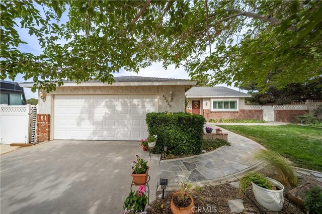 43220 51st St W, Quartz Hill, CA 93536 - ranch-style home featuring a garage, driveway, brick siding, and stucco siding