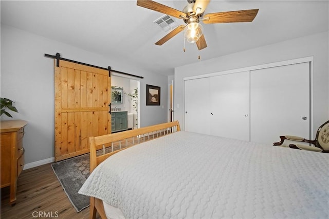 43220 51st St W, Quartz Hill, CA 93536 - bedroom featuring wood finished floors, baseboards, a closet, a ceiling fan, and a barn door