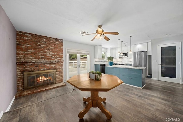 43220 51st St W, Quartz Hill, CA 93536 - dining room featuring ceiling fan, dark wood finished floors, baseboards, and a brick fireplace