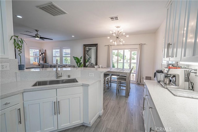 28217 Alton Way, Castaic, CA 91384 - kitchen featuring a sink, open floor plan, a peninsula, white cabinetry, and recessed lighting
