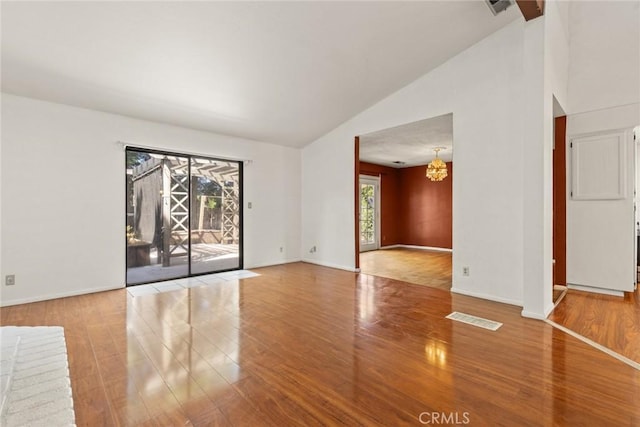 2631 San Jose St, Chico, CA 95973 - empty room featuring wood finished floors, a chandelier, high vaulted ceiling, and baseboards