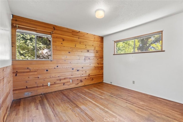 2631 San Jose St, Chico, CA 95973 - unfurnished room with hardwood / wood-style flooring, wooden walls, and a textured ceiling