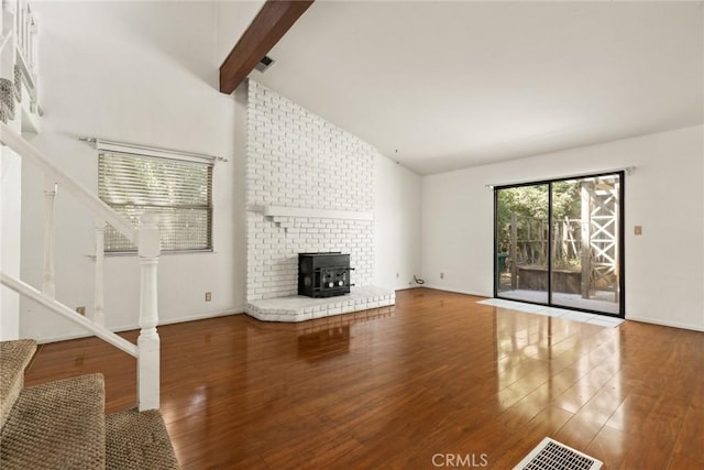 2631 San Jose St, Chico, CA 95973 - unfurnished living room with stairway, wood finished floors, beam ceiling, a wood stove, and high vaulted ceiling