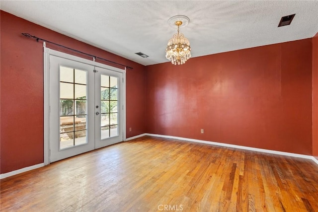 2631 San Jose St, Chico, CA 95973 - spare room featuring french doors, a chandelier, wood finished floors, and a textured ceiling