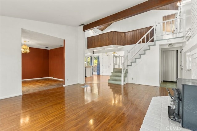 2631 San Jose St, Chico, CA 95973 - unfurnished living room featuring a wood stove, stairway, beamed ceiling, wood finished floors, and a chandelier