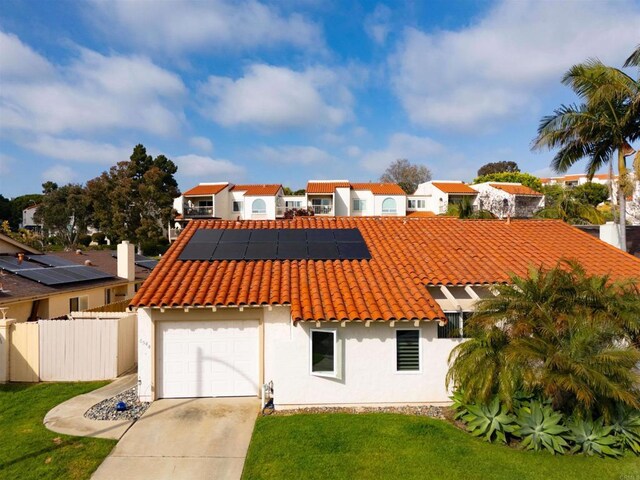 6544 Camino Del Parque, Carlsbad, CA 92011 - mediterranean / spanish house featuring a tiled roof, stucco siding, roof mounted solar panels, a residential view, and driveway